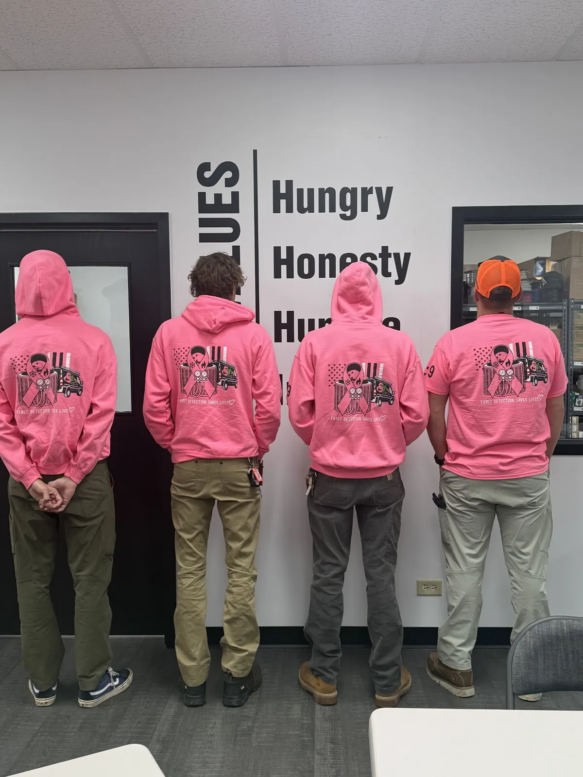 The back of the team's pink hoodies, printed with a ribbon, a GV's van and the words Early Detection Saves Lives.